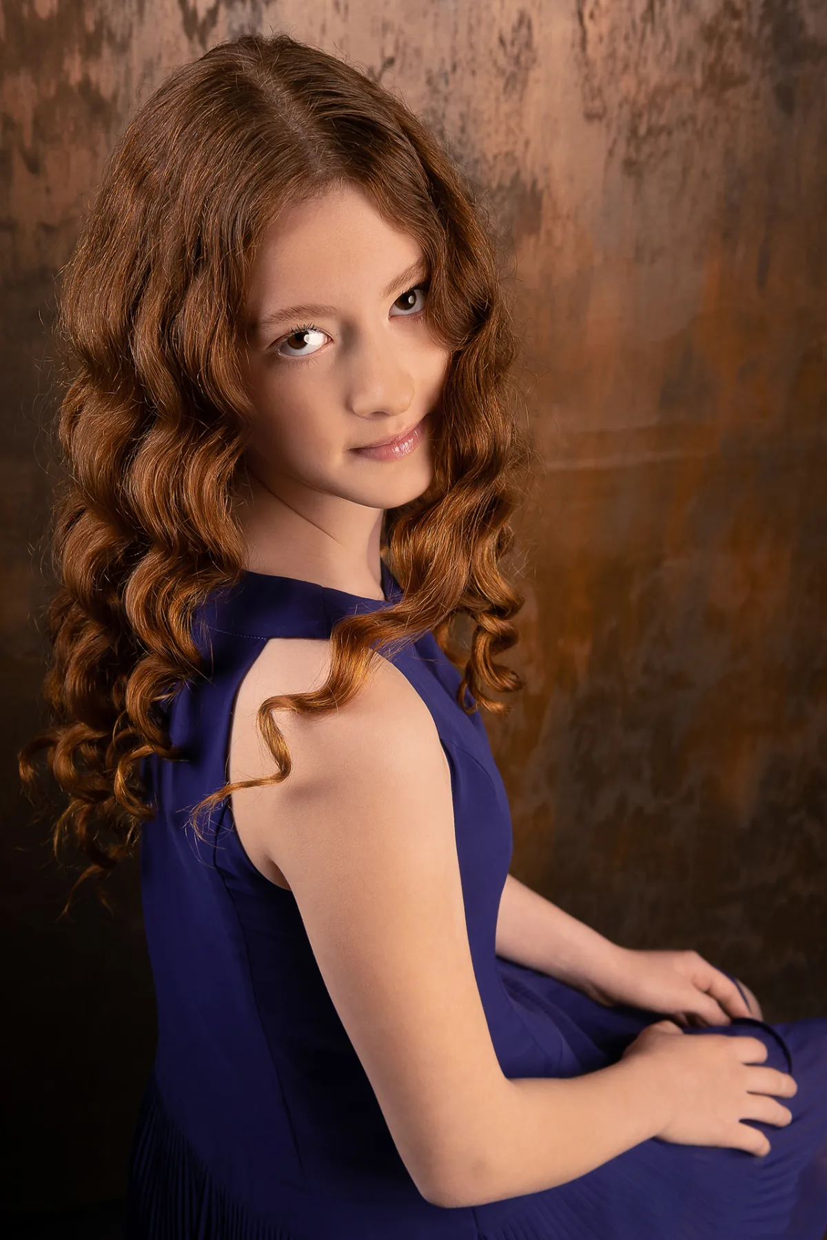 Another beauty portrait of the girl with red curls, blue backdrop