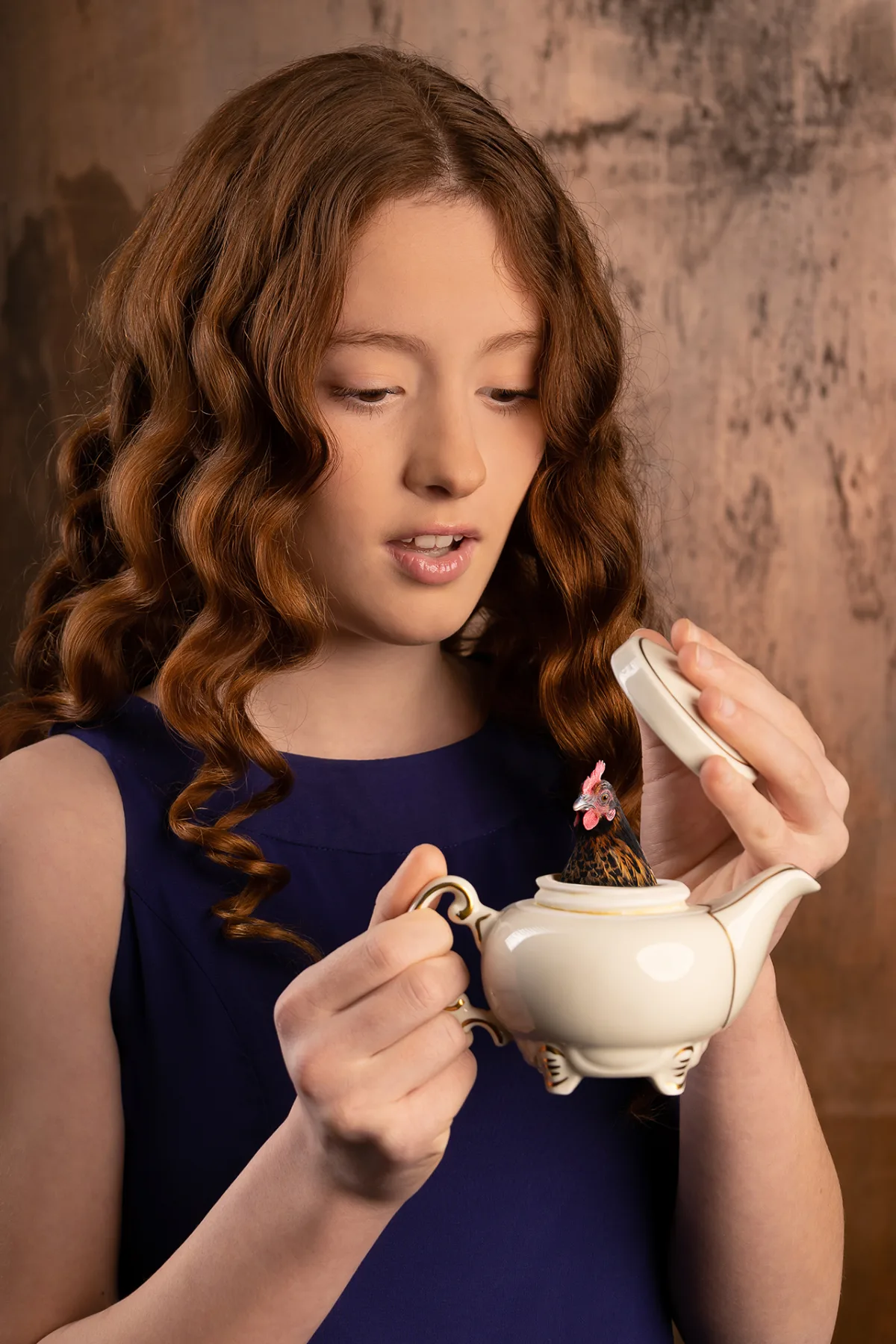 Another beauty portrait of the girl with red curls, blue backdrop