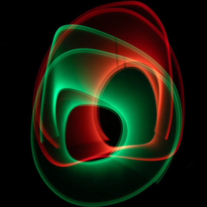 Light painting: intertwined green and red light loops on a black ground